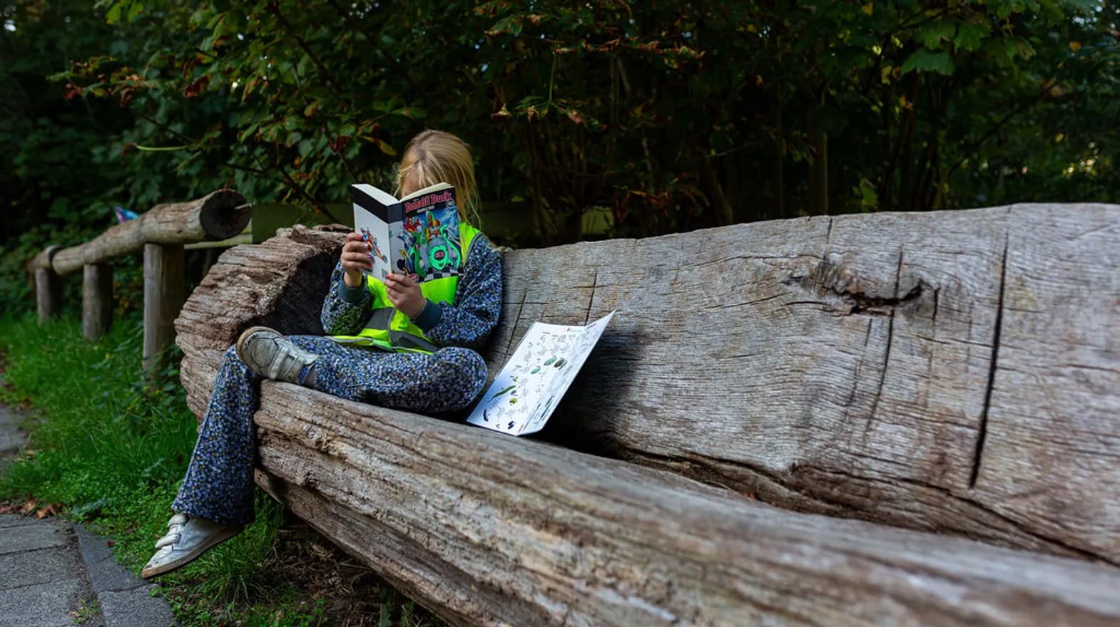 Lekker buiten op de bank lezen bij BSO Scouts Baarn van kinderopvang Kind&co ludens