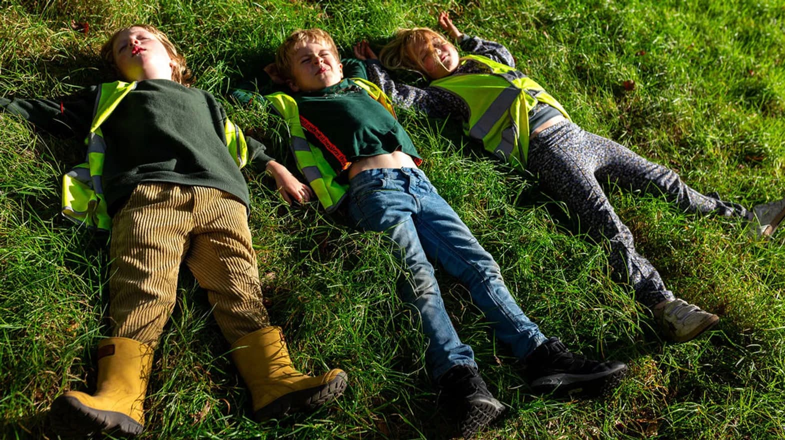 Kinderen relaxen in het gras bij BSO Scouts Baarn van kinderopvang Kind&co ludens
