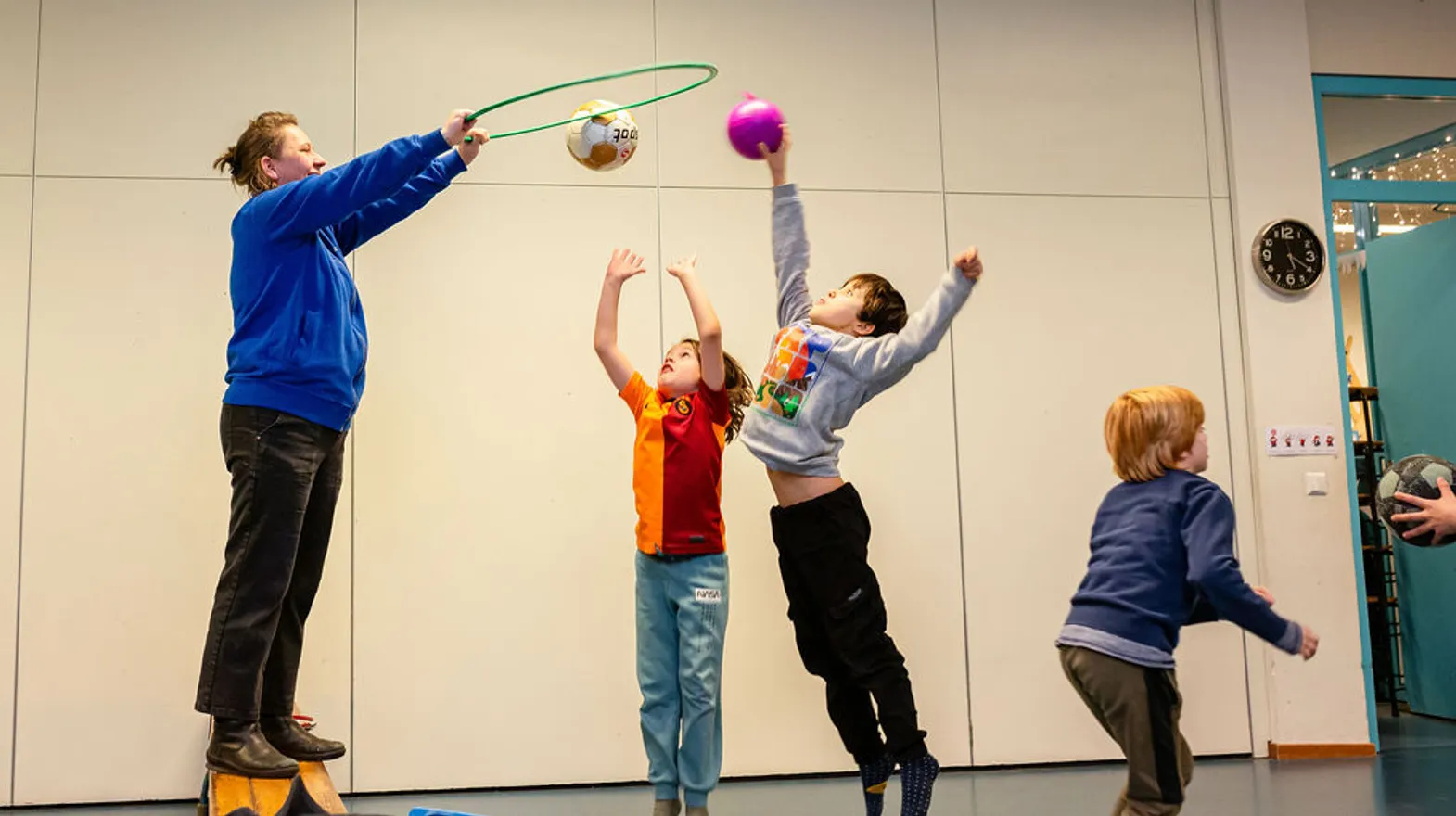 Kinderen spelen een spel in gymzaal van BSO Villa Kinderkeet bij kinderopvang Kind&co Ludens