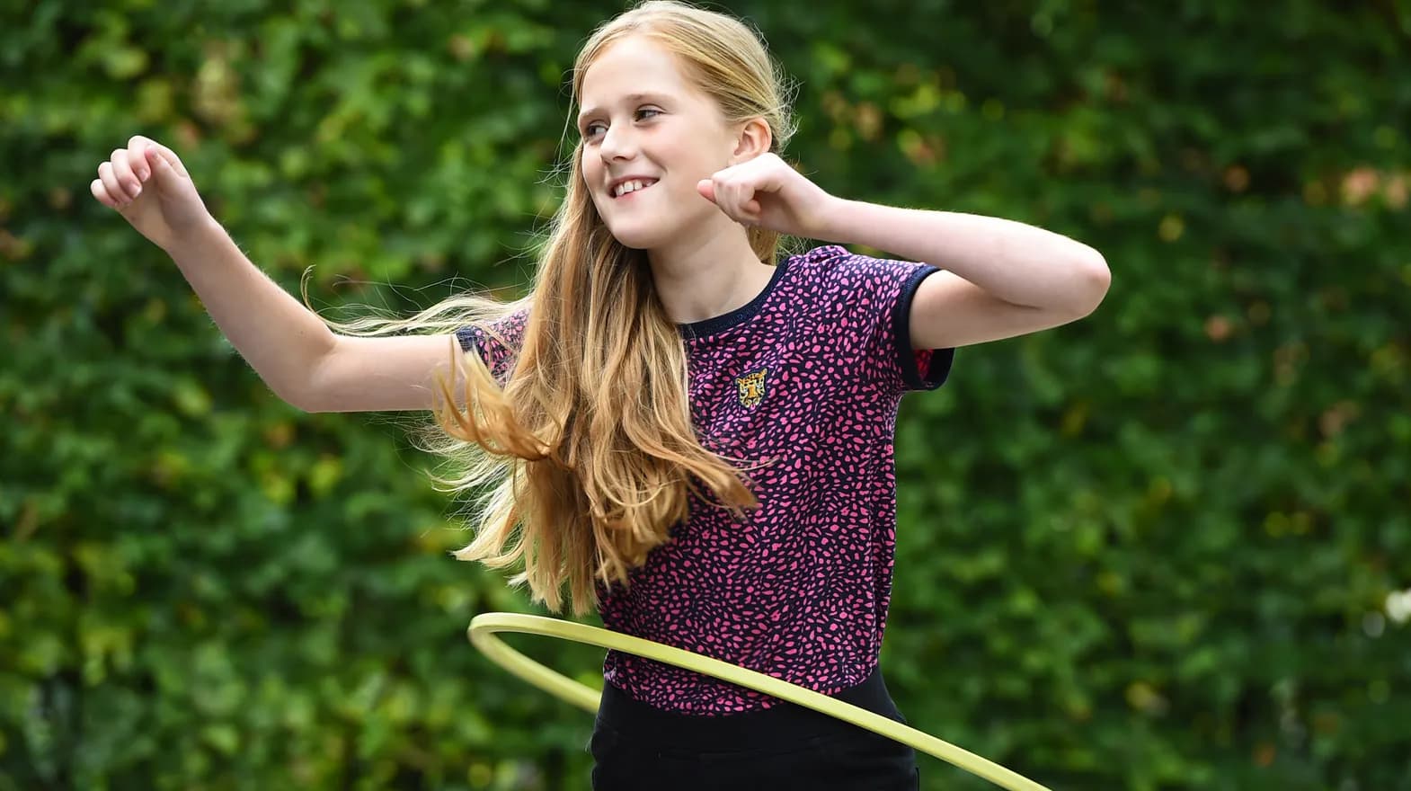 Kind van de BSO hoepelt buiten bij kinderopvang Kind&co ludens