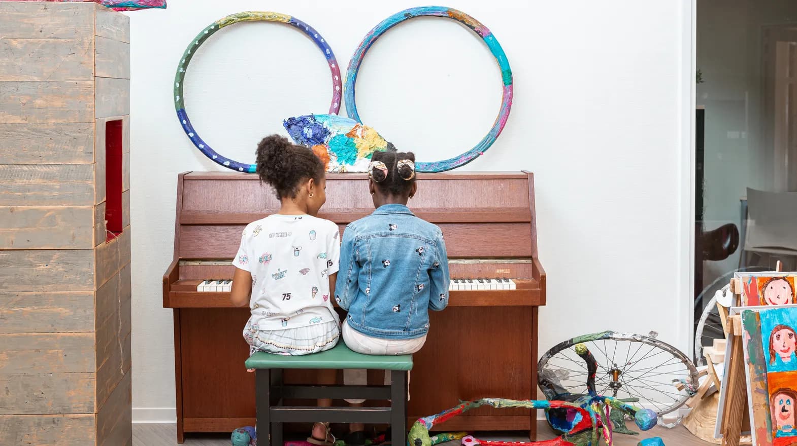 Kinderen spelen samen op de piano bij de BSO van kinderopvang Kind&co ludens