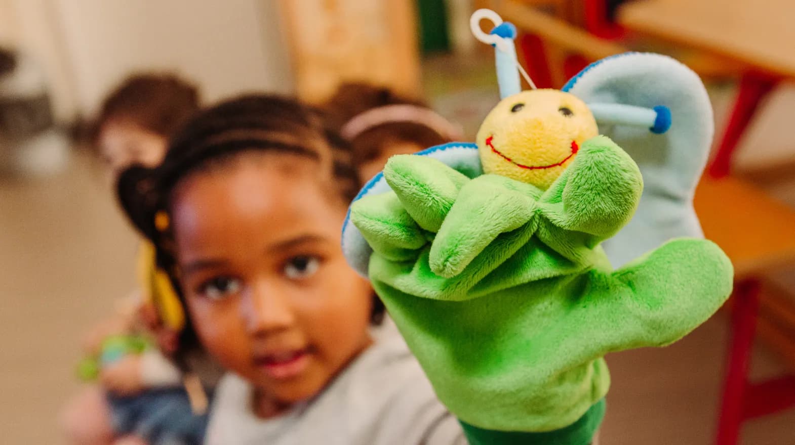 Kind van de peutergroep speelt met handpop bij kinderopvang Kind&co ludens