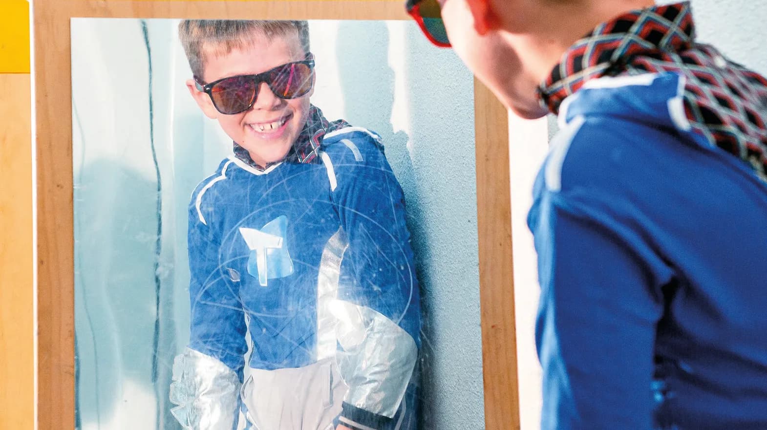 Kind op de BSO heeft veel plezier tijdens een verkleedpartij bij het kijken in de spiegel van kinderopvang Kind&co ludens