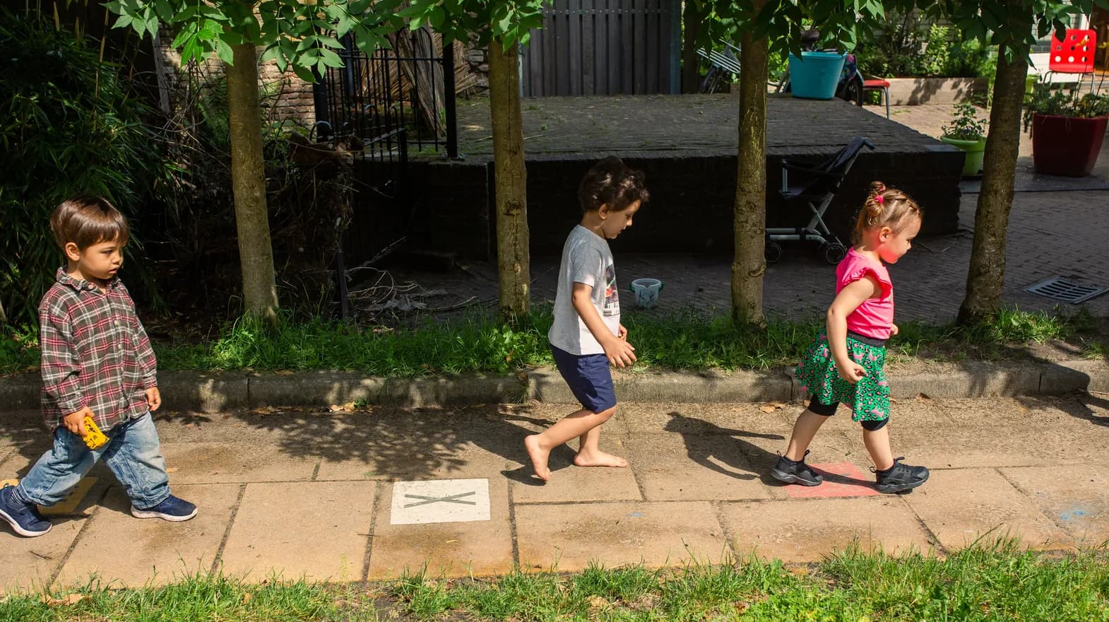 Kinderen lopen door de tuin bij peuteropvang 't Egeltje, Kind&co ludens