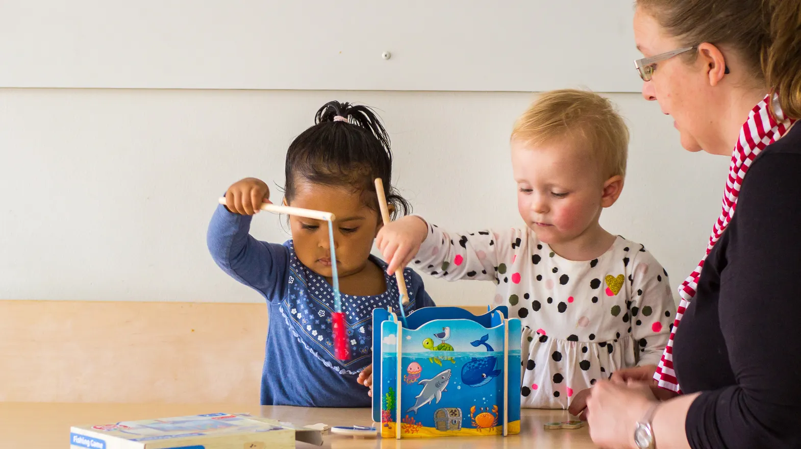 Kinderen spelen samen "Vissen" onder begeleiding van een pedagogisch medewerker bij kinderopvang Kind&co ludens