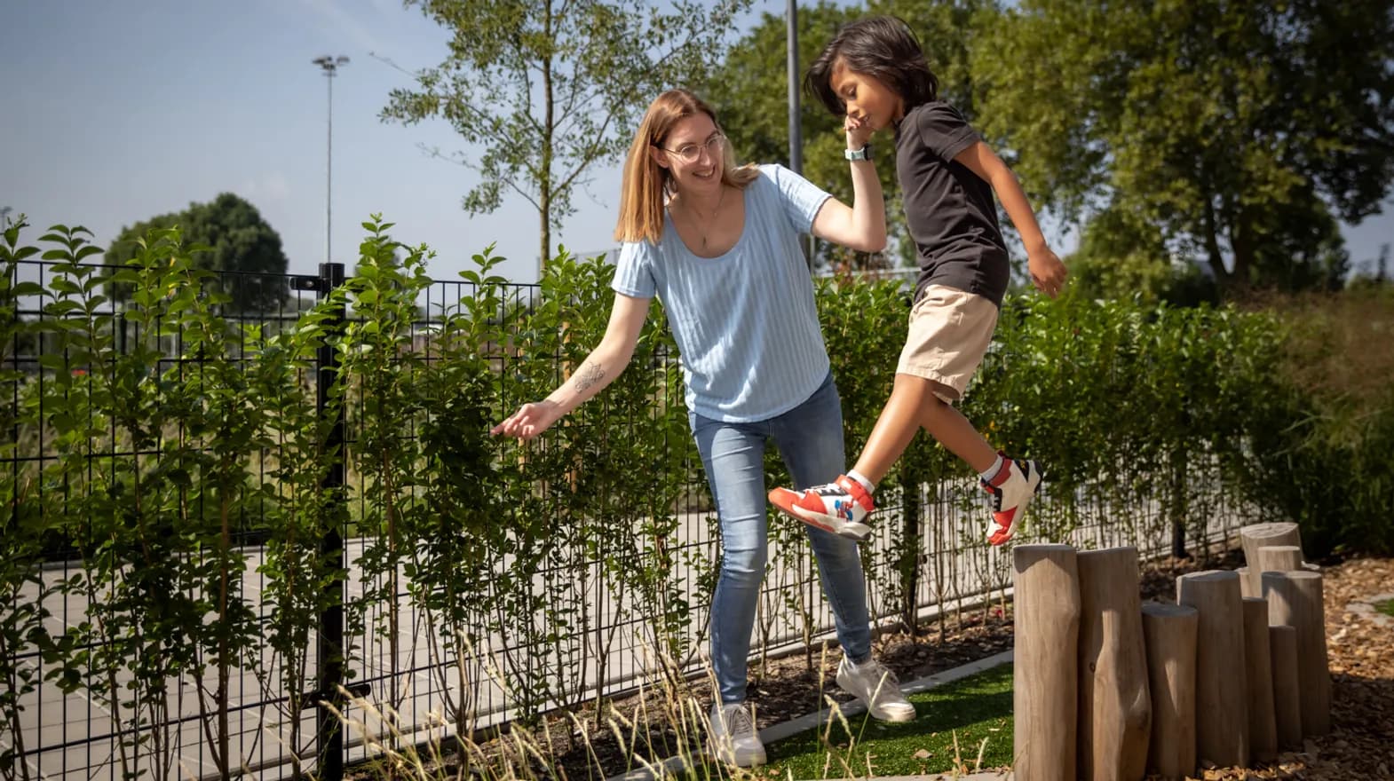 Kind speelt buiten met pedagogisch medewerker bij kinderopvang Kind&co ludens