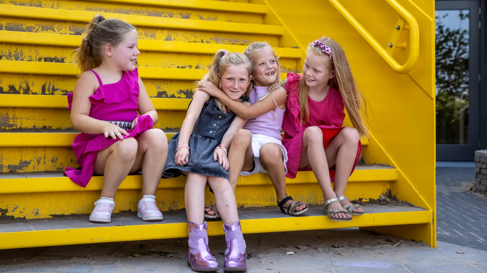 Kinderen kletsen met elkaar op een trap bij kinderopvang Kind&co ludens