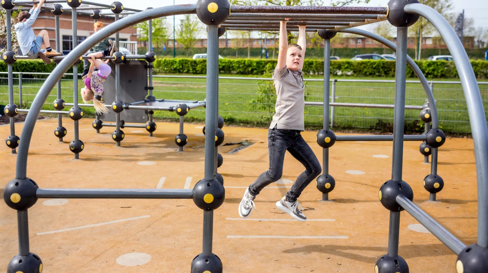 Kinderen spelen buiten in klimrek bij kinderopvang Kind&co ludens
