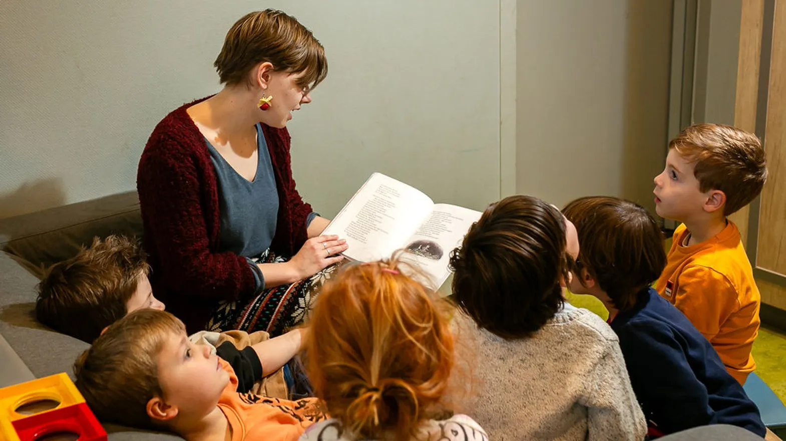 Pedagogisch medewerker leest kinderen voor bij buitenschoolse opvang Odin, Kind&co Ludens