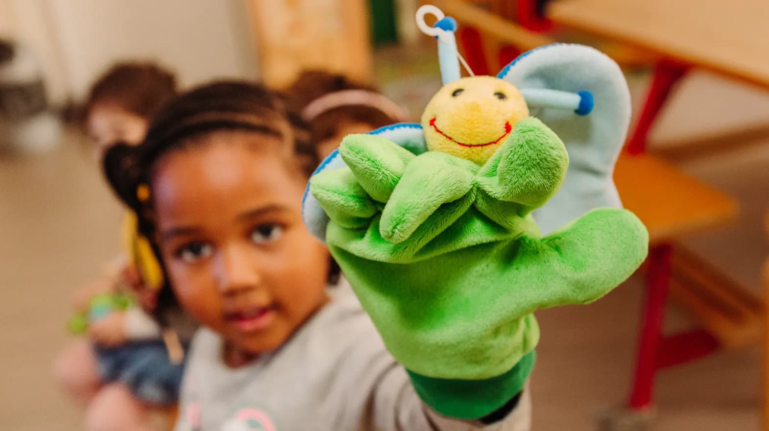 Kind van de peutergroep speelt met handpop bij kinderopvang Kind&co ludens