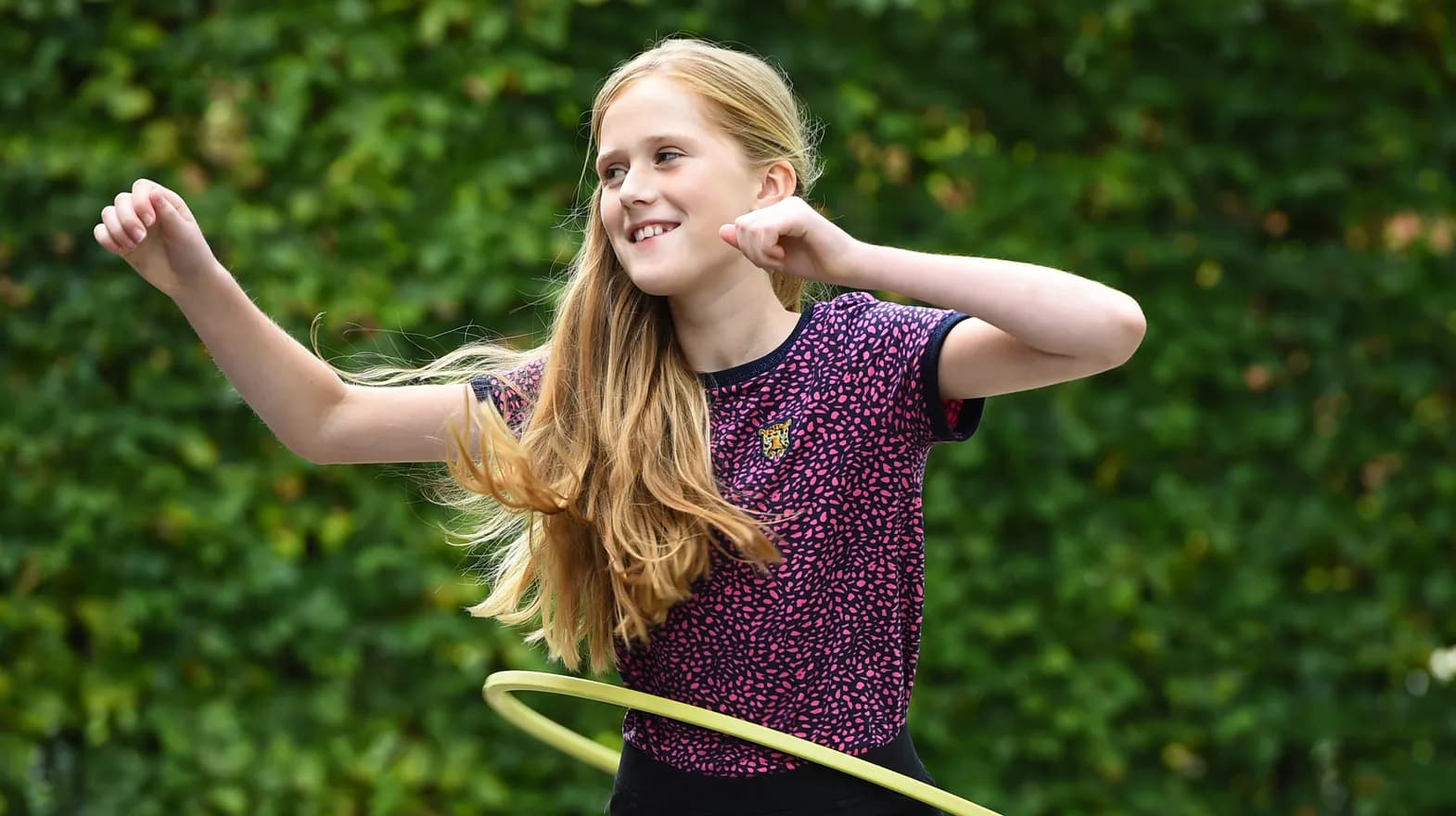 Kind van de BSO hoepelt buiten bij kinderopvang Kind&co ludens