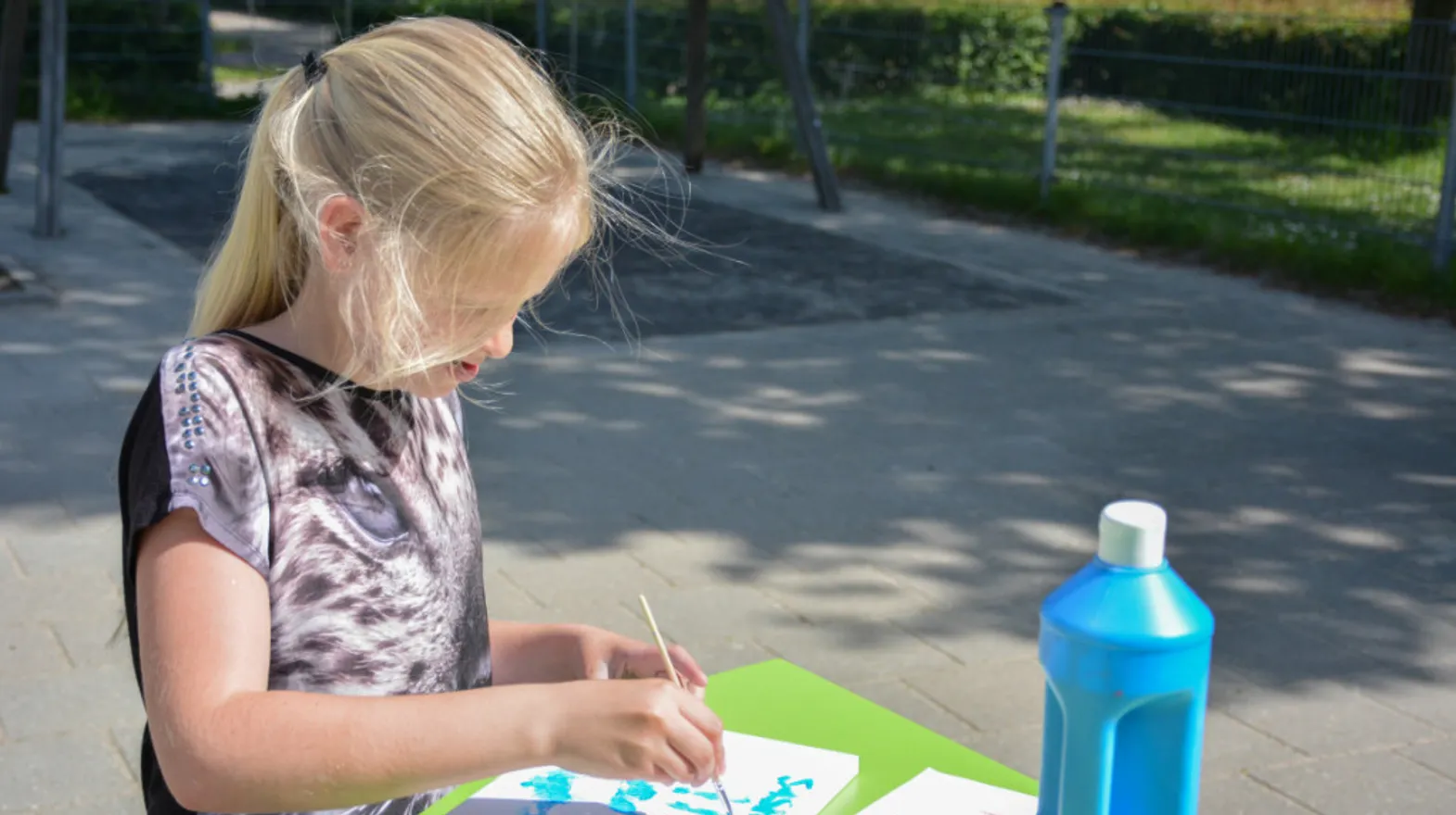 Kind is buiten aan het schilderen bij buitenschoolse opvang wereldwijs van kinderopvang Kind&co ludens