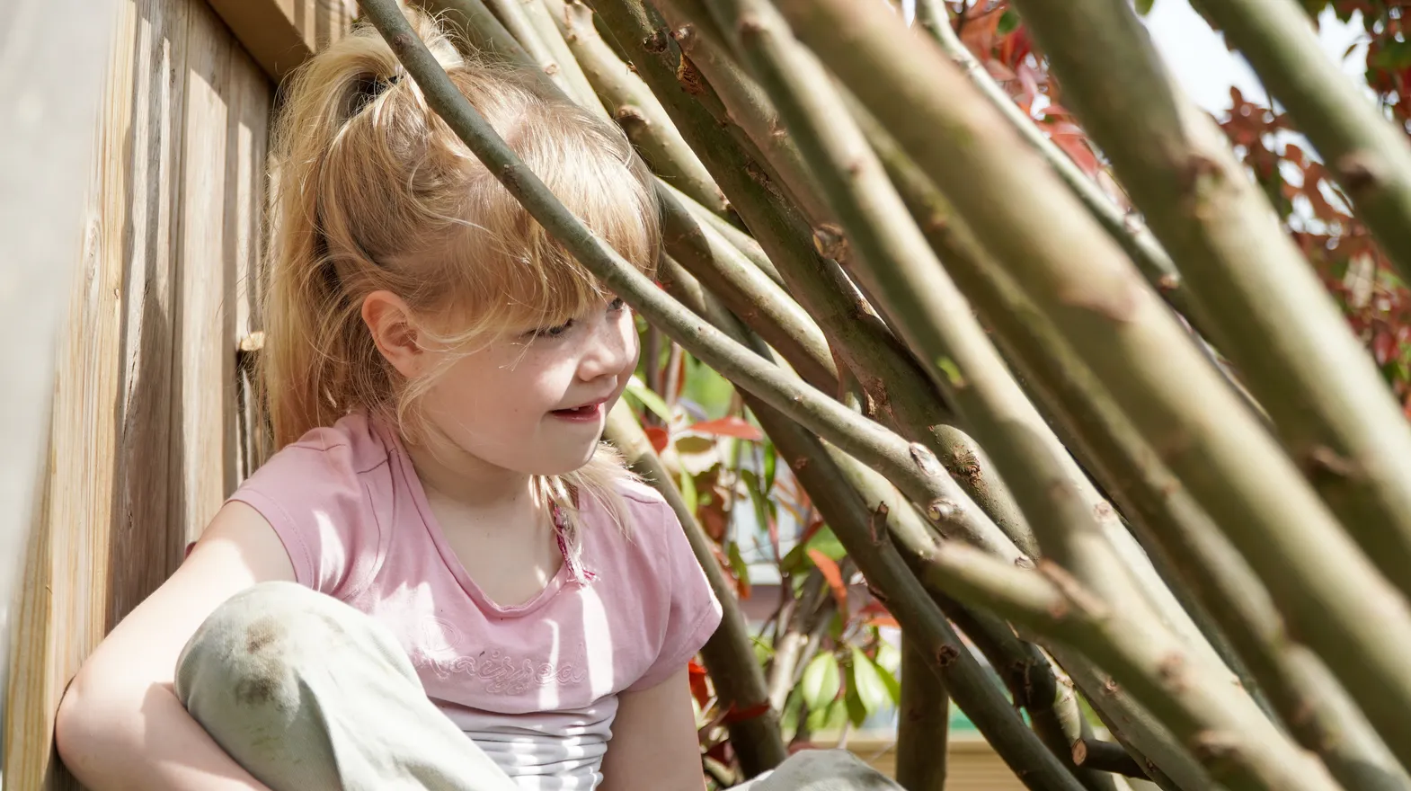 Kind speelt buiten in Wilgentakken huisje bij gastouder van kinderopvang Kind&co ludens