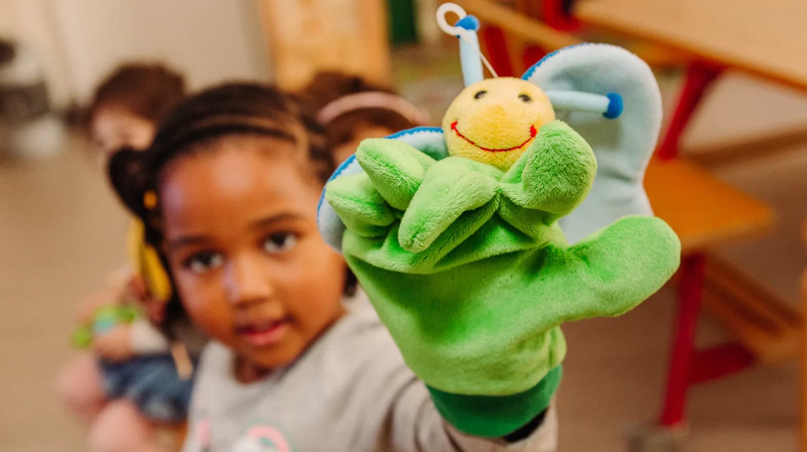 Kind van de peutergroep speelt met handpop bij kinderopvang Kind&co ludens