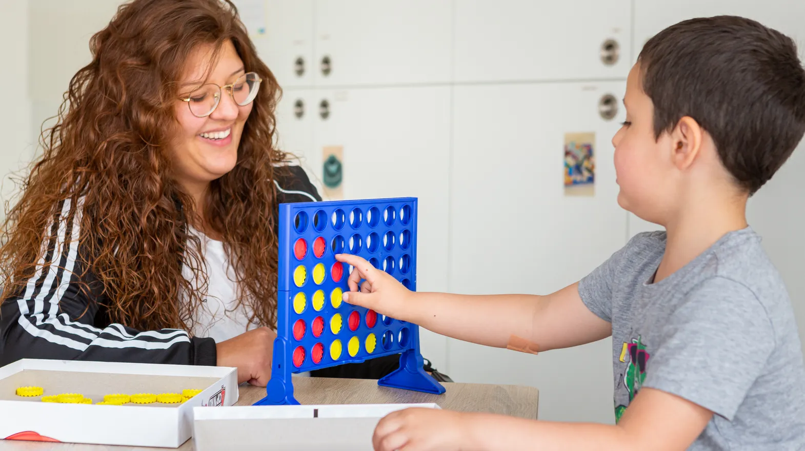 Kind speelt samen met een pedagogisch medewerker een spel bij kinderopvang Kind&co ludens