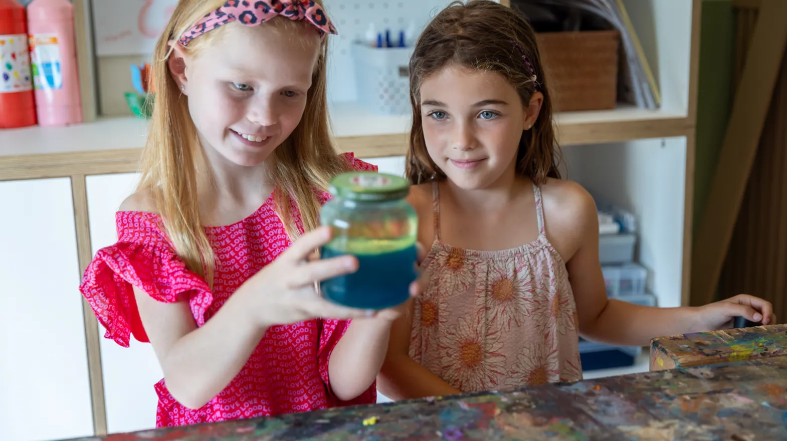 Kinderen kijken naar pot met gekleurd water bij kinderopvang Kind&co ludens