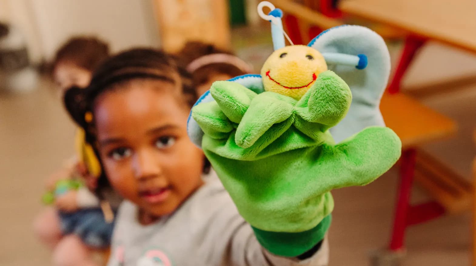 Kind van de peutergroep speelt met handpop bij kinderopvang Kind&co ludens