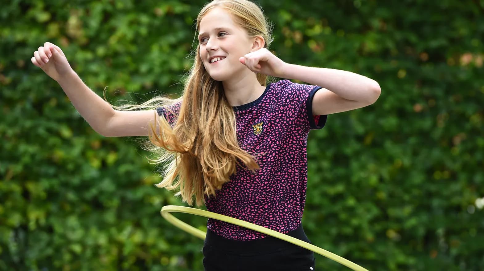 Kind van de BSO hoepelt buiten bij kinderopvang Kind&co ludens