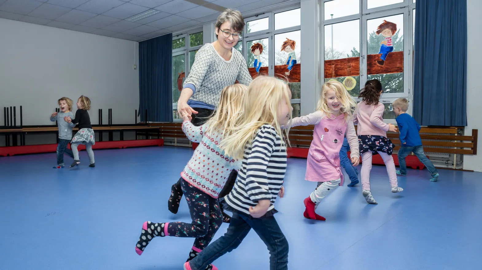 Kinderen van de BSO sporten samen in de gymzaal bij kinderopvang Kind&co ludens