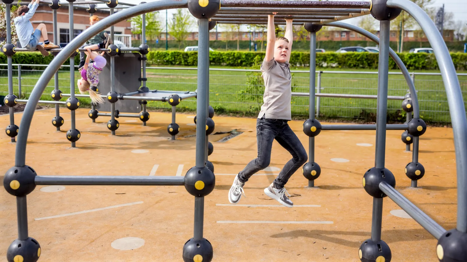 Kinderen spelen buiten in klimrek bij kinderopvang Kind&co ludens