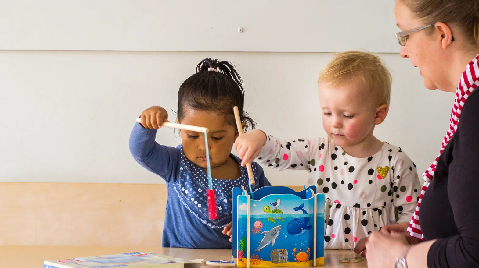 Kinderen spelen samen "Vissen" onder begeleiding van een pedagogisch medewerker bij kinderopvang Kind&co ludens