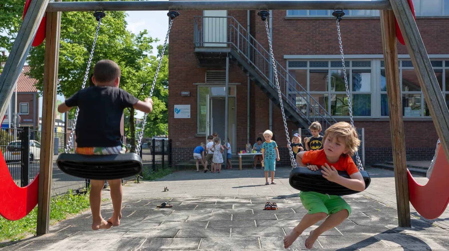 Kinderen spelen buiten op de schommel bij BSO Utrecht De Leeuw van kinderopvang Kind&co ludens