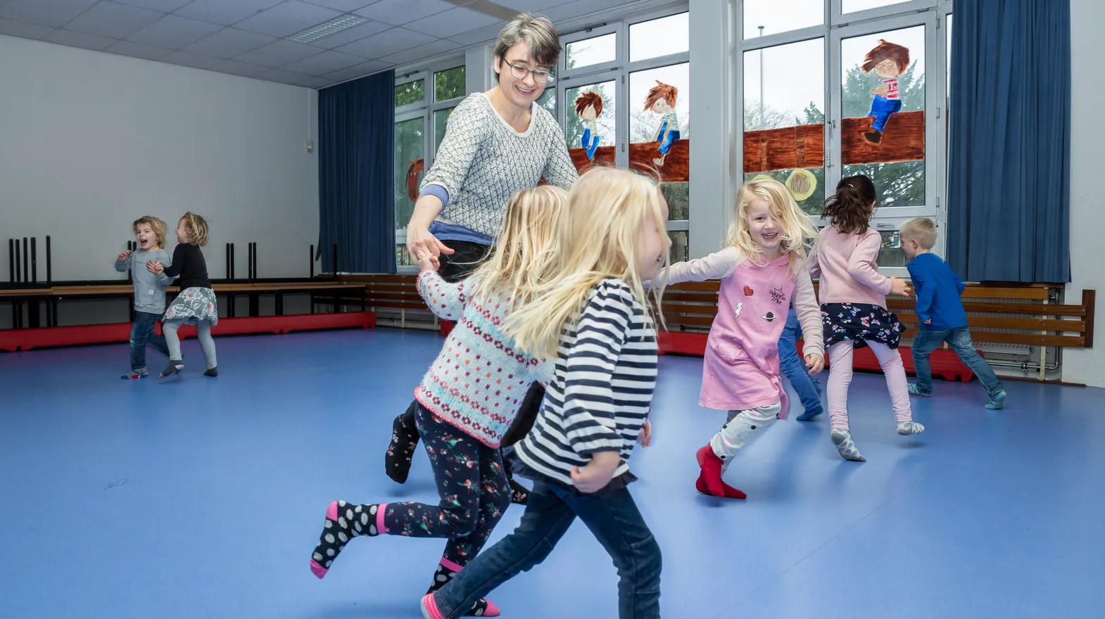 Kinderen van de BSO sporten samen in de gymzaal bij kinderopvang Kind&co ludens