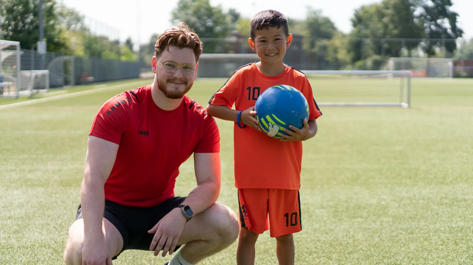 Collega en kind op een sportveld op de BSO