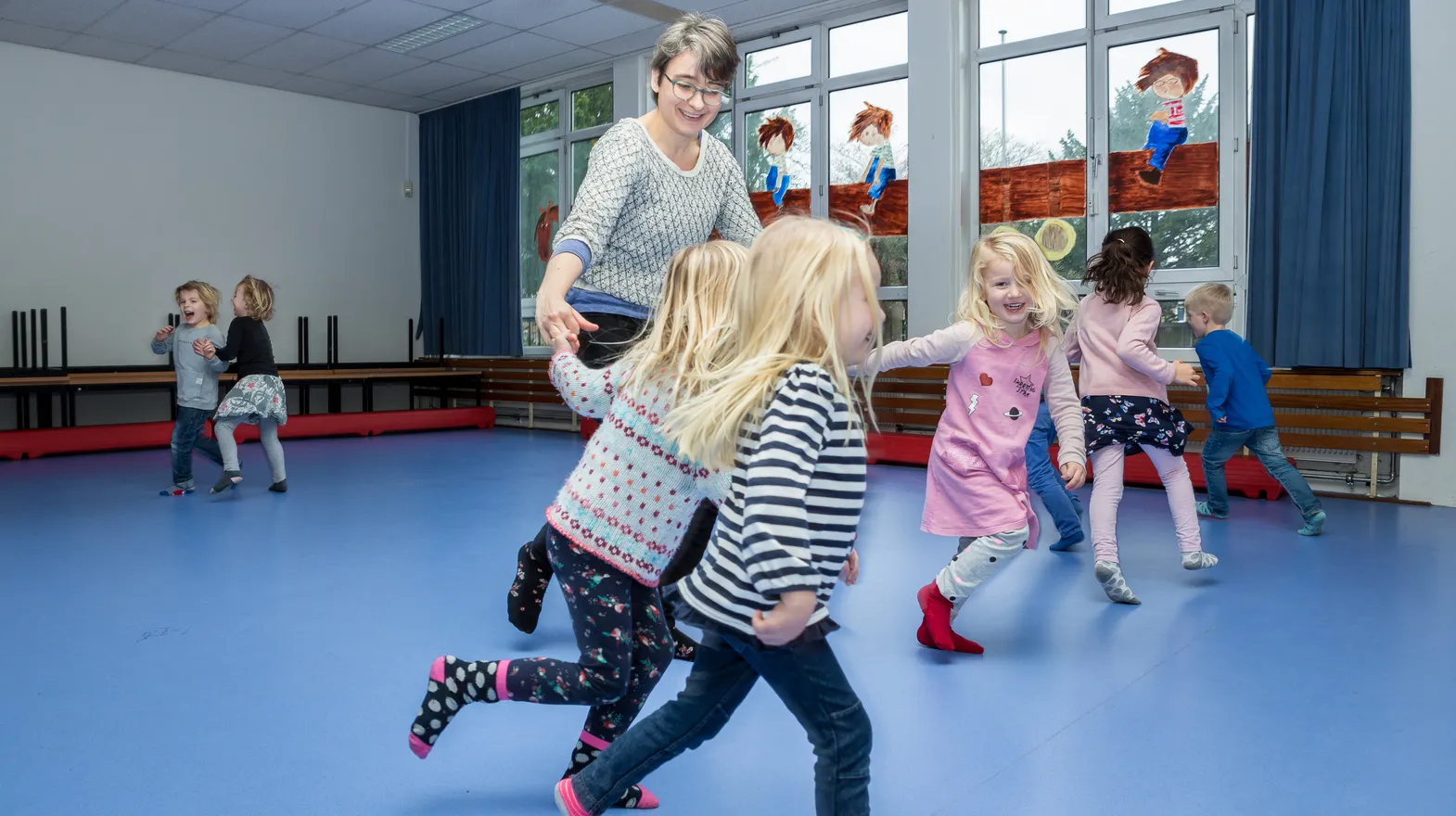 Kinderen van de BSO sporten samen in de gymzaal bij kinderopvang Kind&co ludens