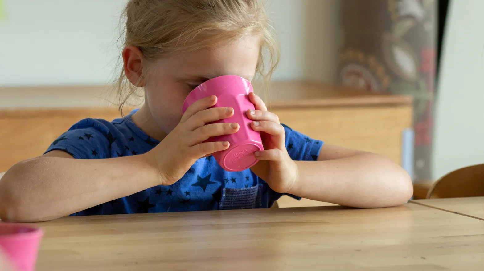 Kind aan tafel met beker drinken bij BSO Utrecht De Leeuw van kinderopvang Kind&co ludens
