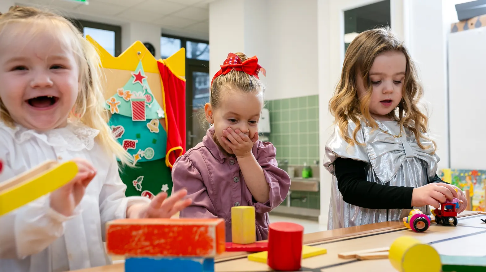 Kinderen van de peutergroep lachen en spelen samen bij kinderopvang Kind&co ludens