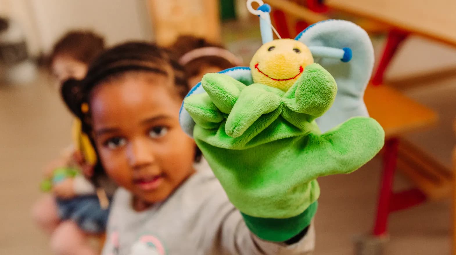 Kind van de peutergroep speelt met handpop bij kinderopvang Kind&co ludens
