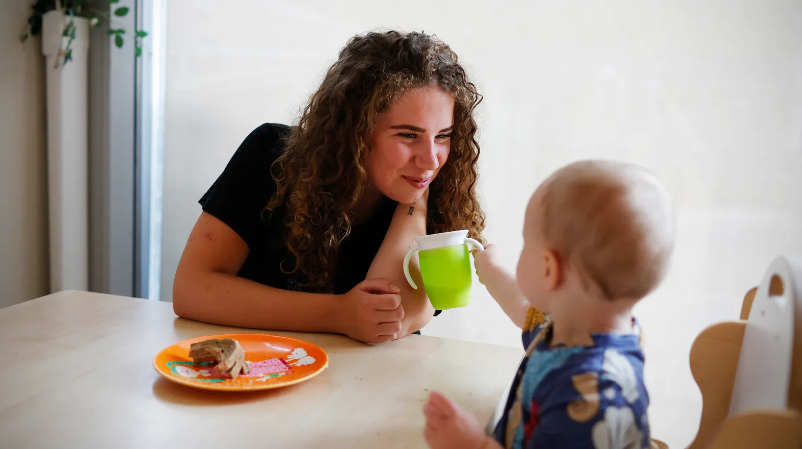 Kind eet samen met pedagogisch medewerker bij kinderopvang Kind&co ludens