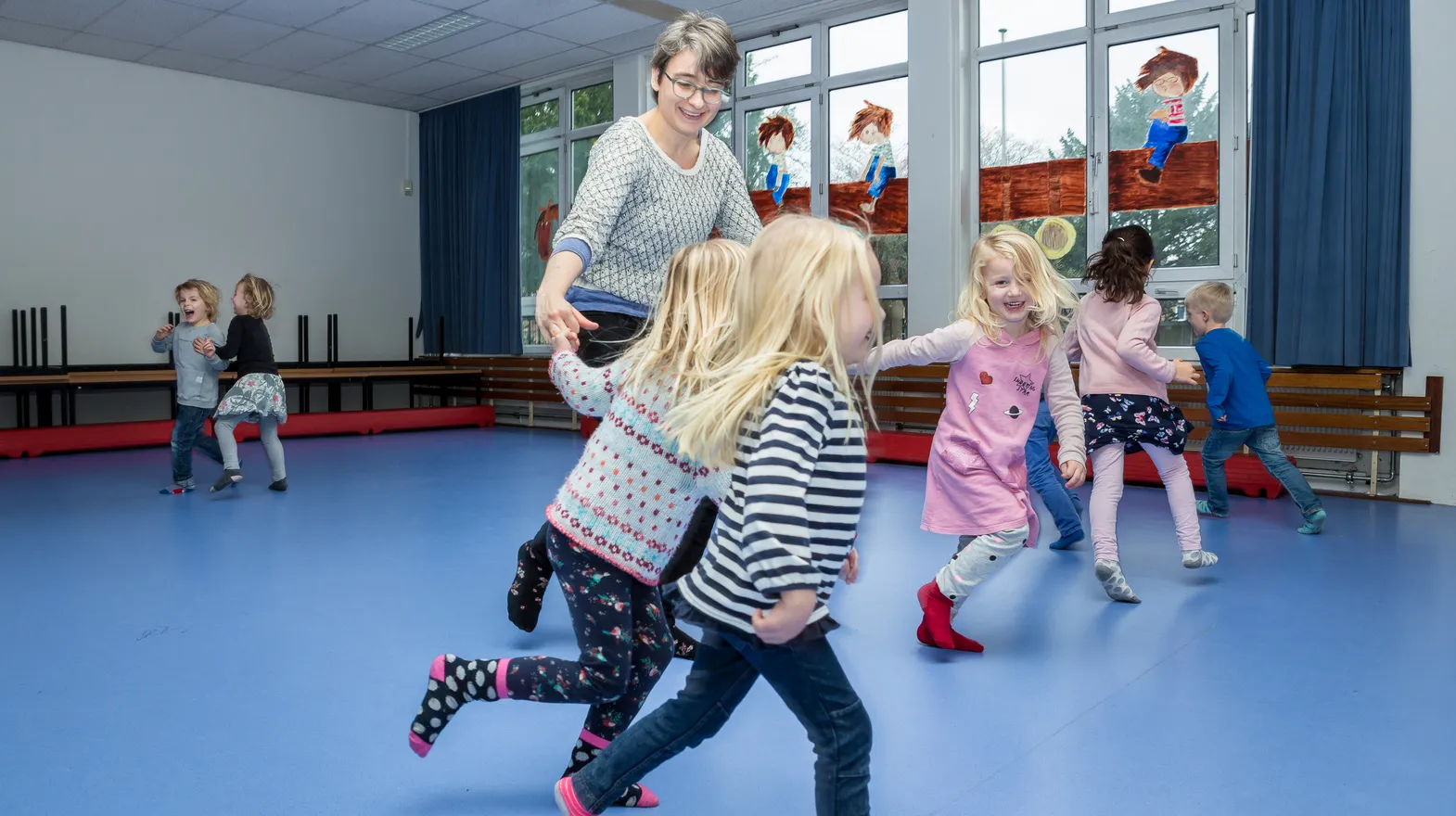 Kinderen van de BSO sporten samen in de gymzaal bij kinderopvang Kind&co ludens