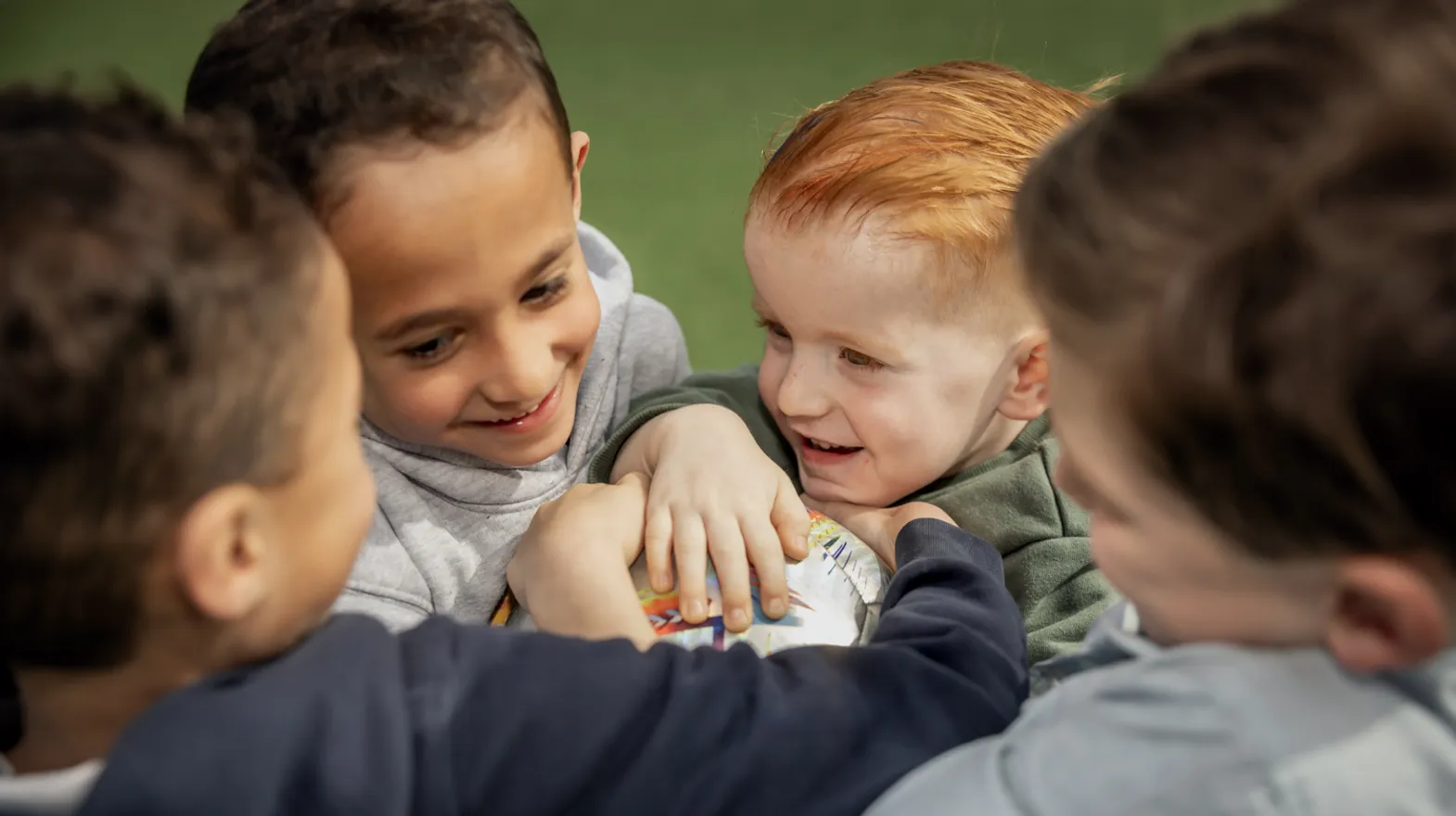 Kinderen spelen een bal en lachen met elkaar bij kinderopvang Kind&co ludens
