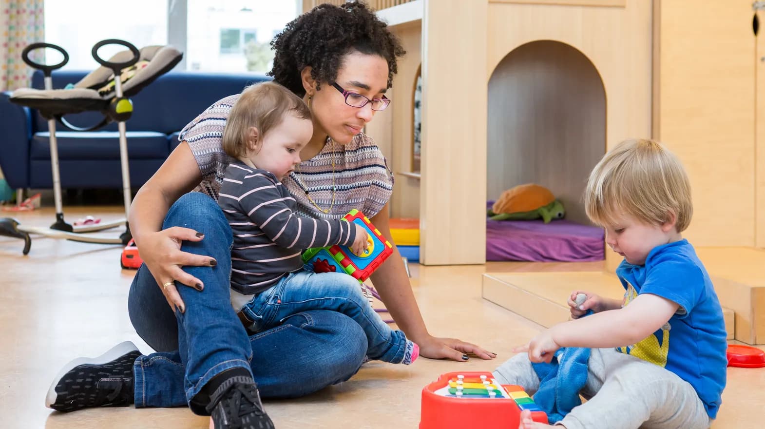 Kinderen spelen samen onder begeleiding van een pedagogisch medewerker bij kinderopvang Kind&co ludens
