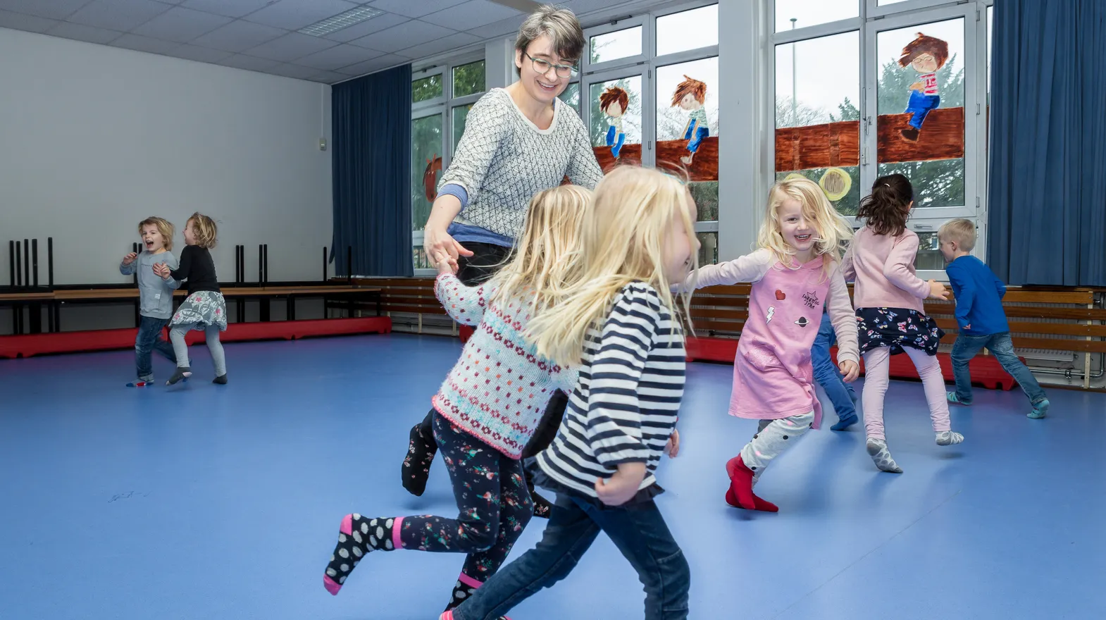 Kinderen van de BSO sporten samen in de gymzaal bij kinderopvang Kind&co ludens