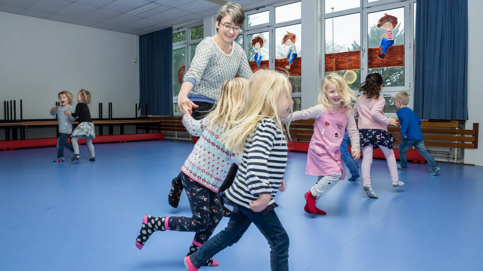 Kinderen van de BSO sporten samen in de gymzaal bij kinderopvang Kind&co ludens