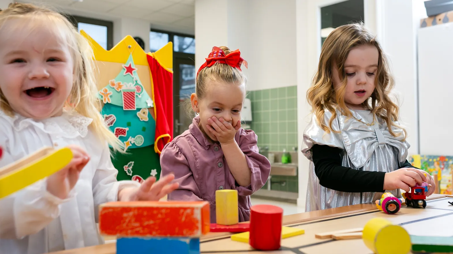 Kinderen van de peutergroep lachen en spelen samen bij kinderopvang Kind&co ludens