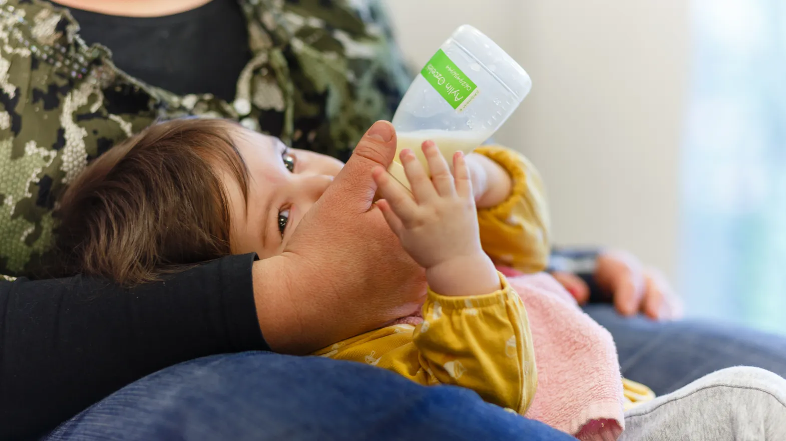 Baby krijgt een flesje melk van pedagogisch medewerker bij kinderdagverblijf Harlekijn, kinderopvang Kind&co ludens