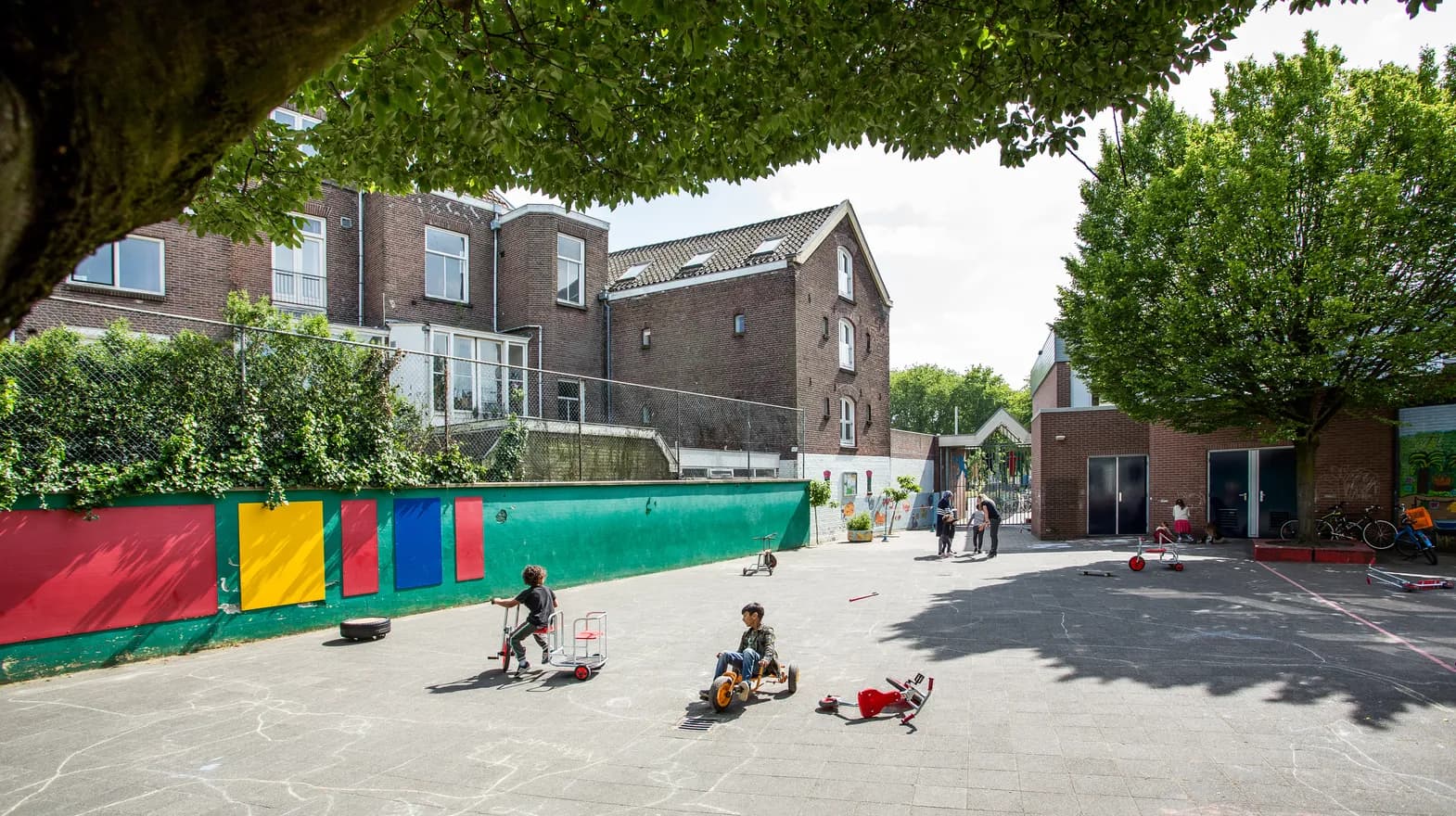 Spelende kinderen op het schoolplein van buitenschoolse opvang Maanvis, kinderopvang Kind&co Ludens