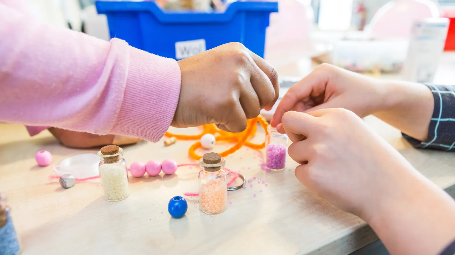 Kinderen die kralen rijgen van BSO Utrecht Spoenk bij kinderopvang Kind&co ludens