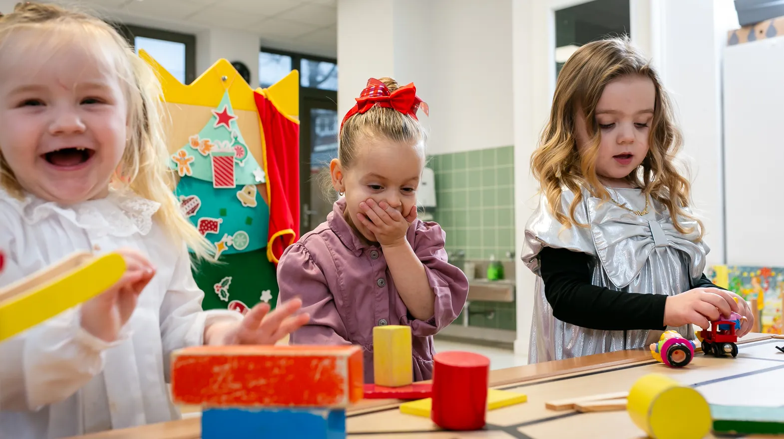 Kinderen van de peutergroep lachen en spelen samen bij kinderopvang Kind&co ludens