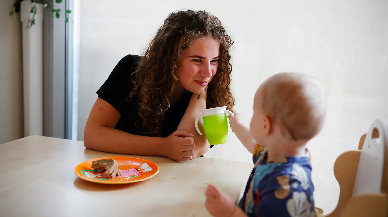 Kind eet samen met pedagogisch medewerker bij kinderopvang Kind&co ludens