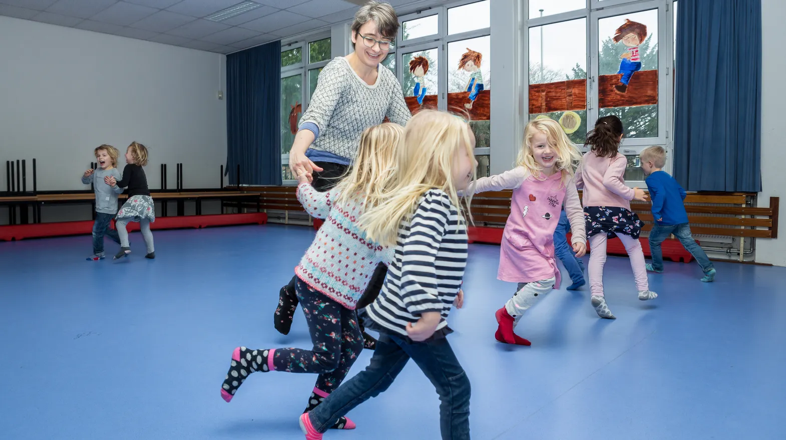 Kinderen van de BSO sporten samen in de gymzaal bij kinderopvang Kind&co ludens