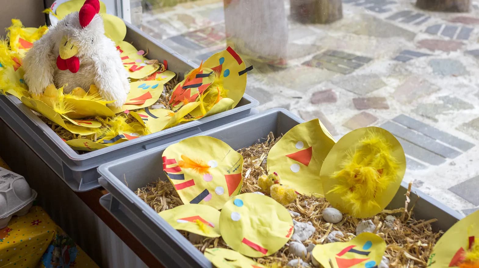 Door de kinderen geknutselde kippen in een bak stro bij peuteropvang Winnie de Pooh, Kind&co ludens