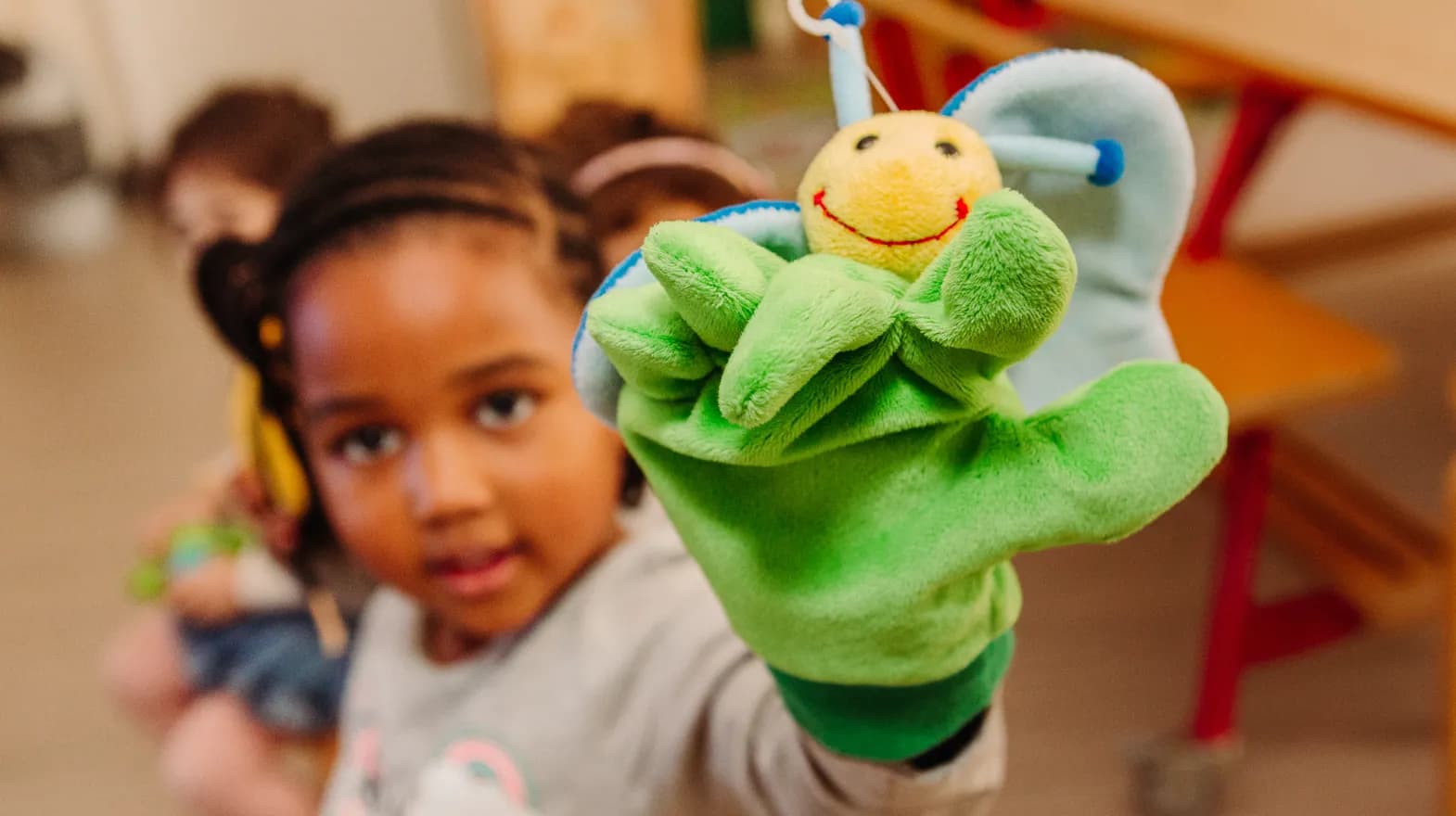 Kind van de peutergroep speelt met handpop bij kinderopvang Kind&co ludens