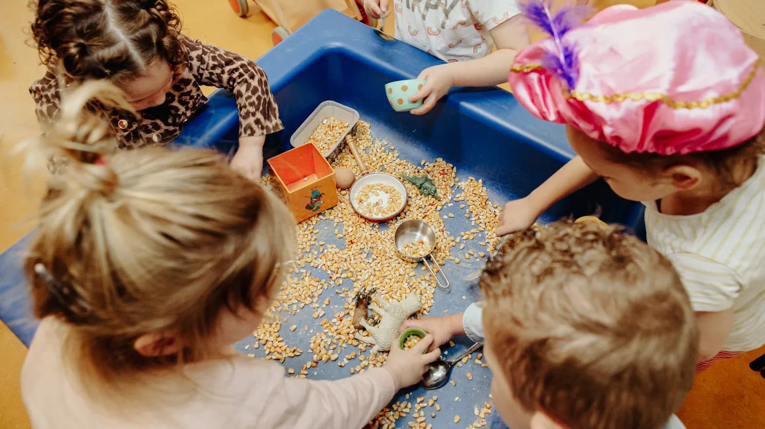 Kinderen spelen met mais bij peuteropvang Pinokkio, Kind&co Ludens