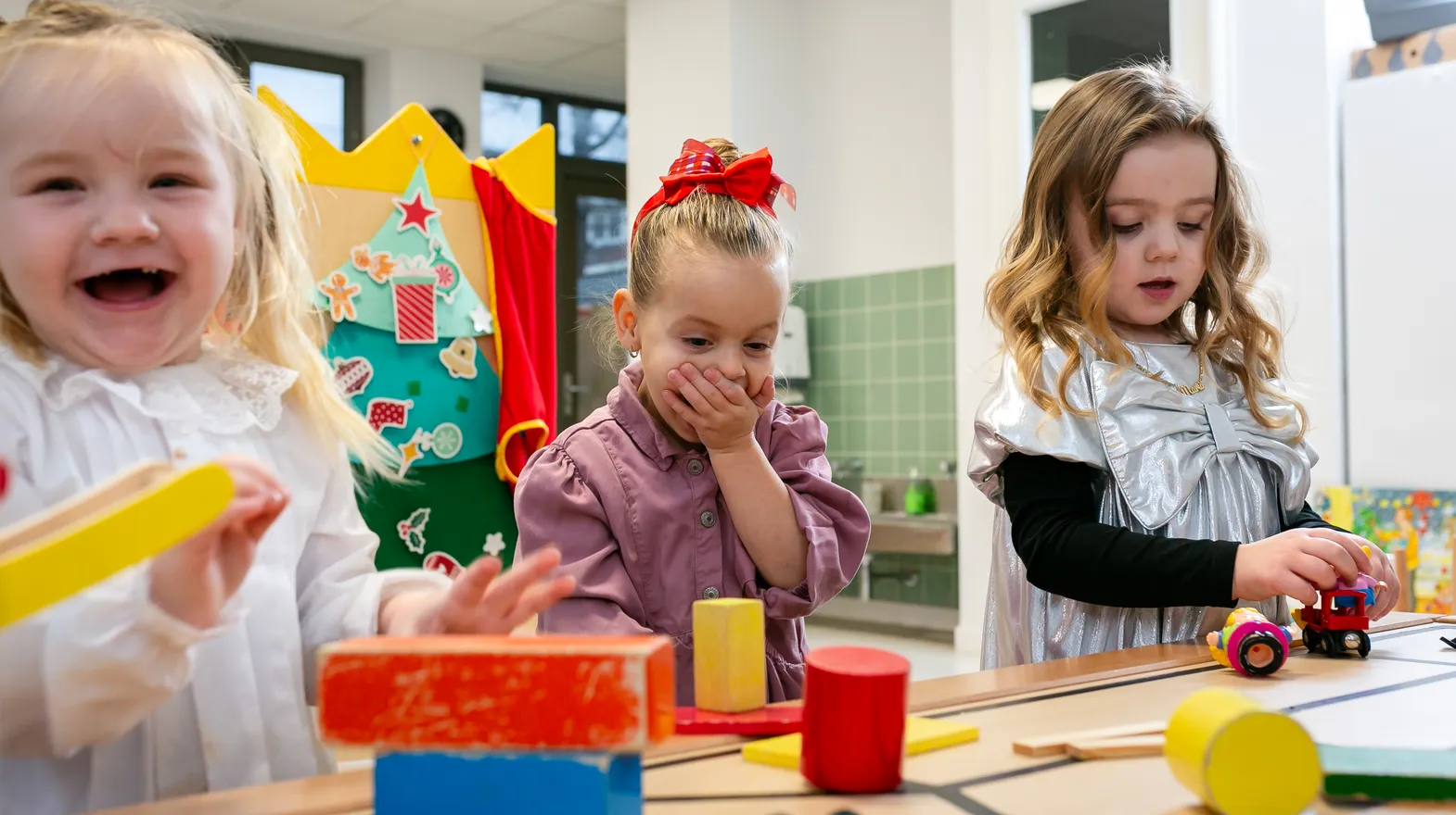 Kinderen van de peutergroep lachen en spelen samen bij kinderopvang Kind&co ludens