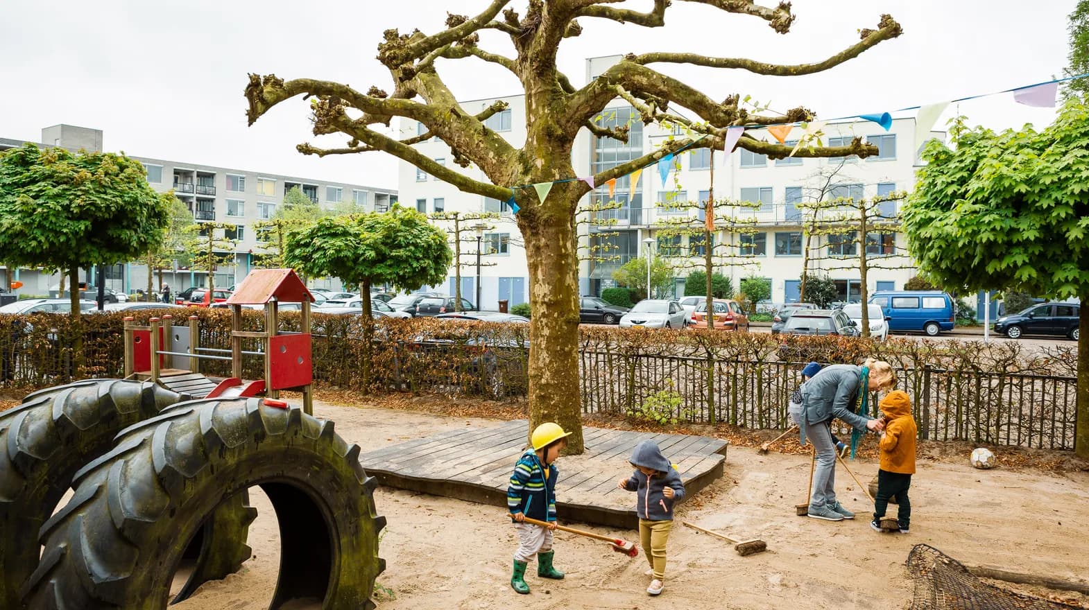 Kinderen vegen buiten het zand bij elkaar bij kinderdagverblijf Villa Kakelbont, kinderopvang Kind&co ludens